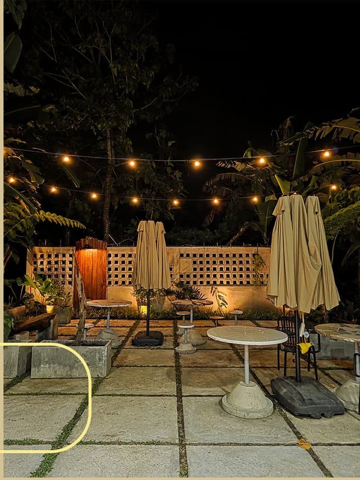 String lights over the seating area after dark